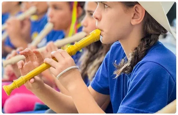Alunos tocando flauta doce durante a aula de música